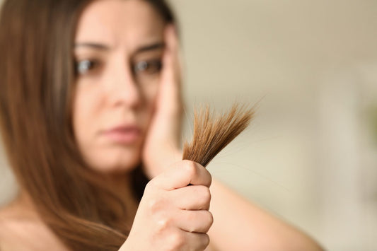 Woman holding her hair strands with split ends