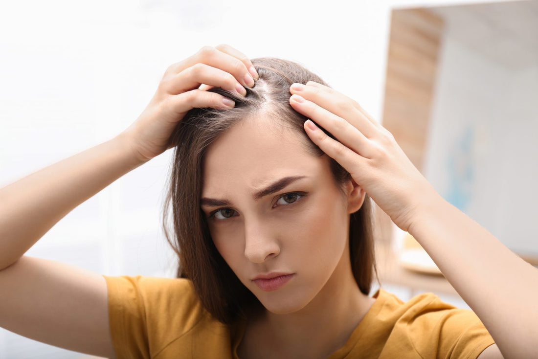 A woman inspecting her hair line for a bald spot