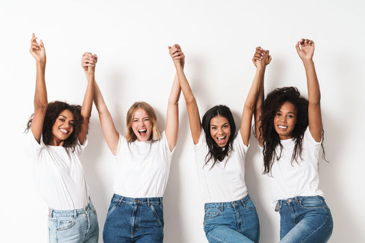 Women holding hands raised up and smiling