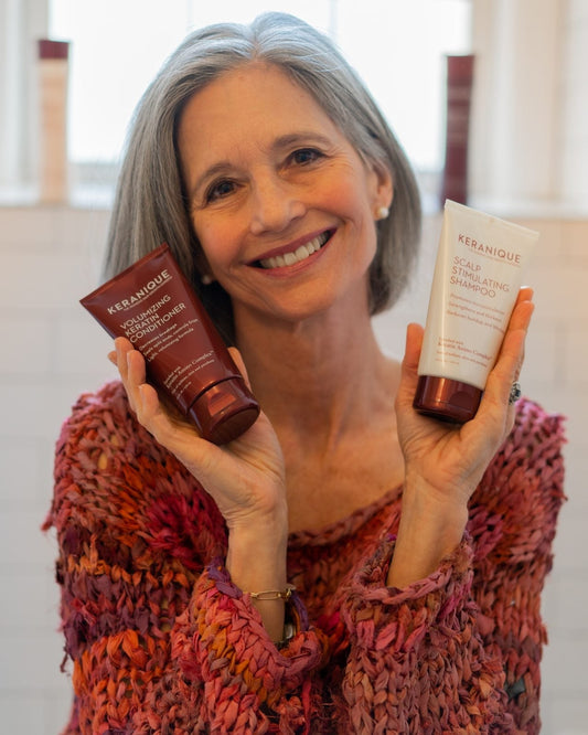 Woman with short hair holding a couple of keranique hair products