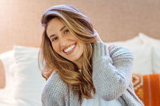 A woman in grey sweater smiling