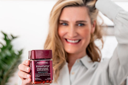 A woman holding keranique hair supplements 