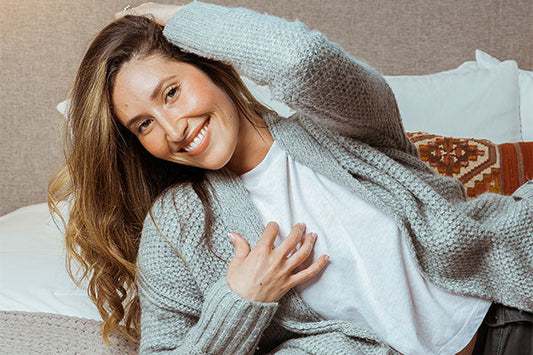 A woman in a grey sweater smiling 