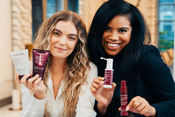 2 women smiling and holding keranique products