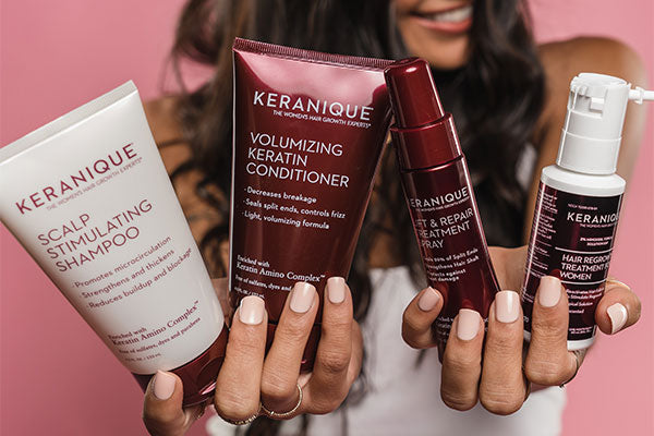 Woman holding Keranique hair care products