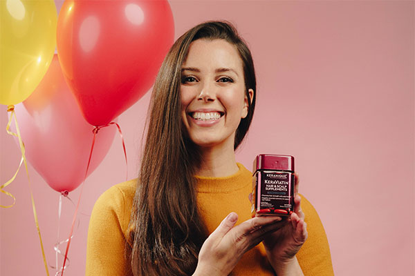 A woman holding keranique hair supplement