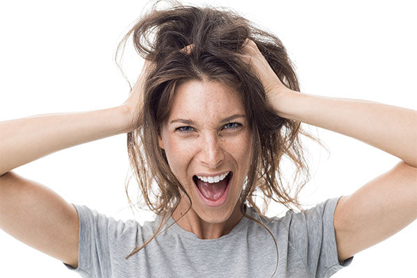 woman with gray shirt grabbing her hair 