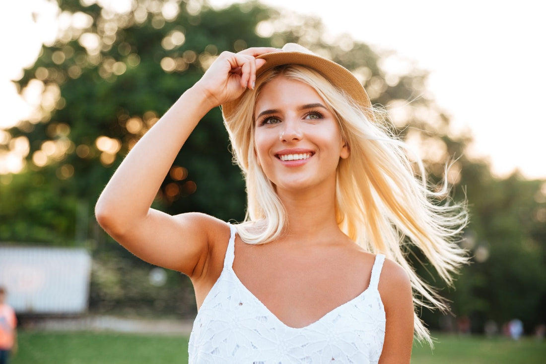 A woman in white dress with a hat outdoors