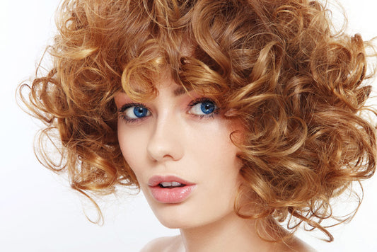 Woman with blue eyes and brownish red curly hair 