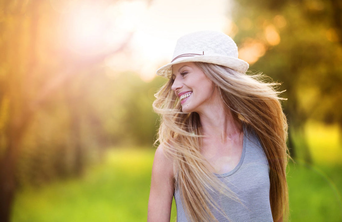 Woman with healthy hair smiling outdoors.