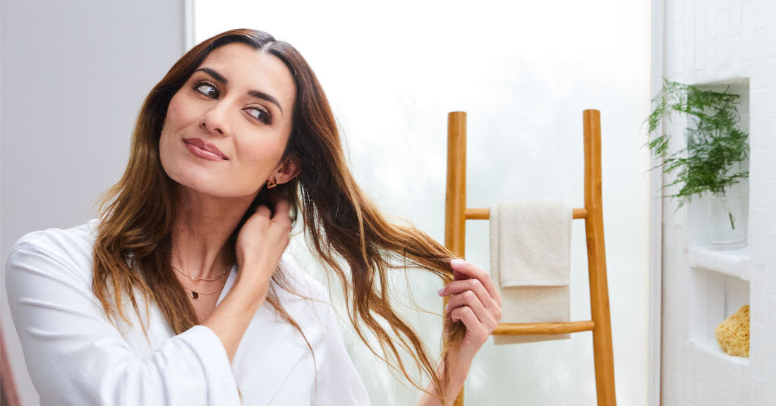 Woman admiring her moist hair.